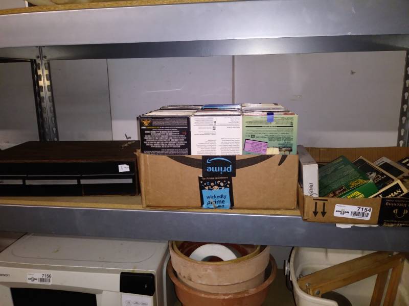 lot 7154 image: Lot of VHS tapes and a tape storage holder.