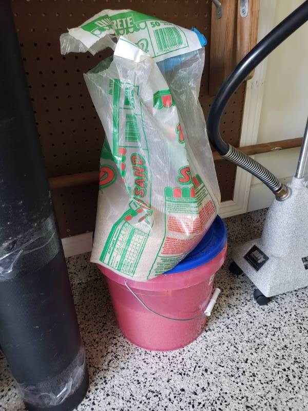 lot 7513 image: Bucket with and partial bag of sand.