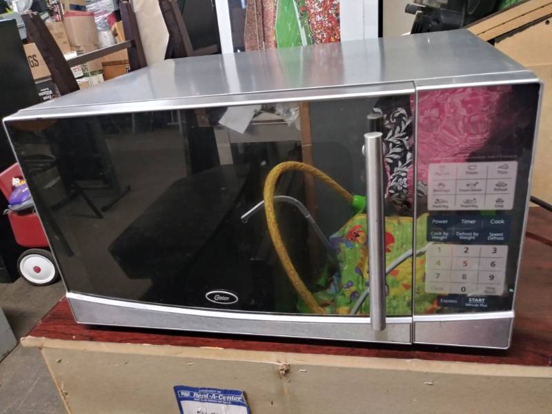 lot 1729 image: Oster Stainless Steel Countertop Microwave