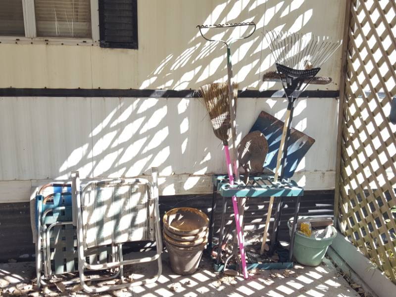 lot 3756 image: Long Handle Tools with Holder, Lawn Chairs and Plastic Pots on Porch