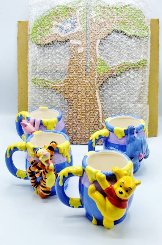 lot 1846 image: Disneys Winnie The Pooh Mug Tree and 4 Collectible Mugs. New In Box