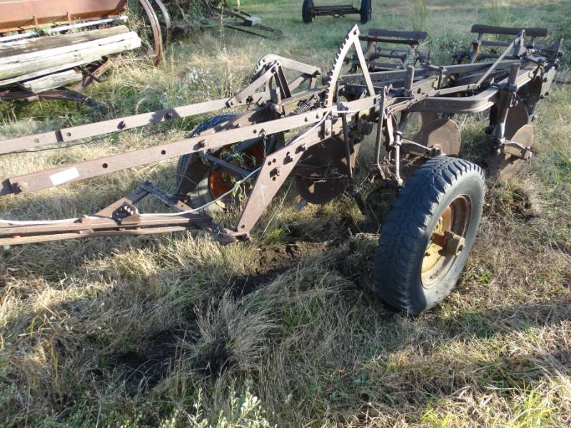 lot 2922 image: Old metal wheel farm implement- pull behind 3 bottom plow