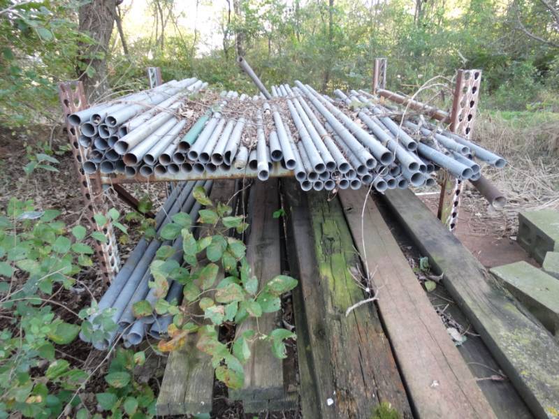 lot 2954 image: Section of pallet rack w large lot of metal pipe & misc.