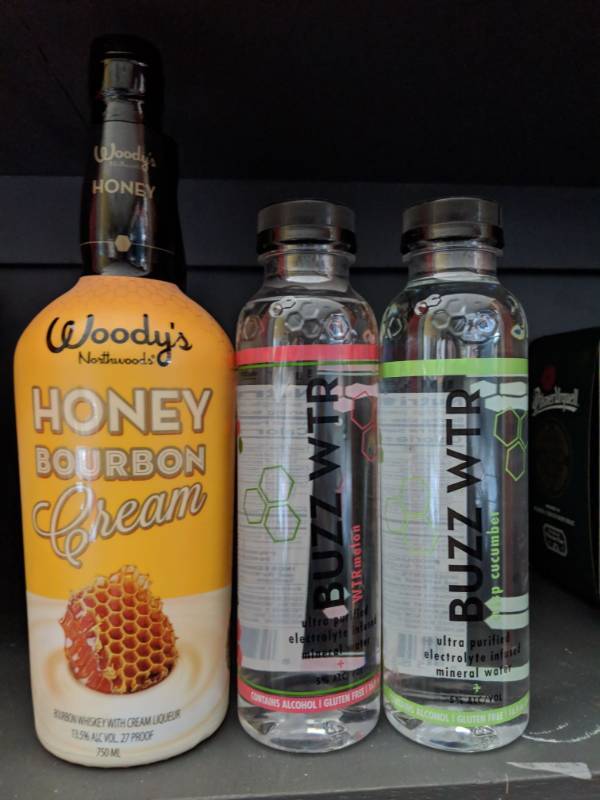 lot 9814 image: (4) Bottles (2) 750mL Woodys Honey Bourbon Cream 13.5 Perc Alc By Vol, (2) 16.9Oz Of Buzzwater-1 Wtrmelon- 1 Crisp Cucumber 5Perc Alc By Vol
