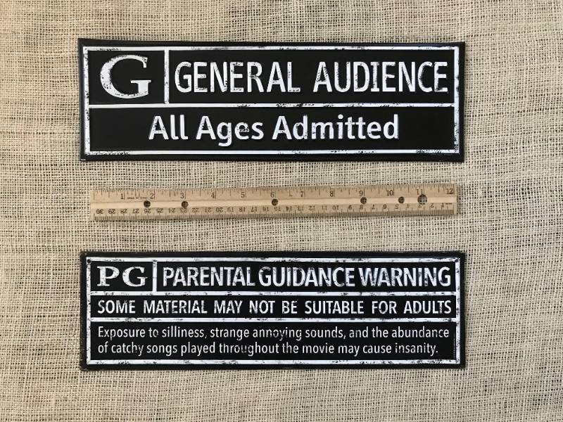 lot 1128 image: Set of two tin movie wall decor pieces