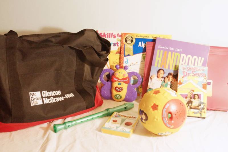 lot 1417 image: Early Childhood learning toys with carrying bag- Girl Scout Handbook- Alphabet book-First grade skills book-song flute- The musical ball plays music ,lights up, and names the animals on it.