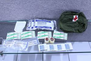 lot 2858 image: Small Army Surplus First Aid Bag with Bandages and Tape 6.5x8