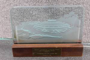 lot 2909 image: Vintage Wichita Convention & Visitors Bureau Partnership Award from 1990. Century Two Image Carved into Glass on Wood Base 10x7x2.5