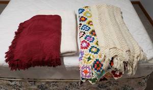 lot 4189 image: Lot of BlanketsThrows - 1 Off White Cotton Blanklet, 1 Burgundy Cotton Throw, 1 Multi-colored Afghan, and 1 Cream Afghan Throw