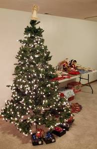 lot 4363 image: Lot of Christmas Decorations - No. 1 Lighted 7 ft. Christmas Tree, Tree trimmings, 20 pc. Porcelian Dinnerware Set, Blue Christmas Plates, Holiday Linens, Santa & Mrs. Claus Figurines and Other Items - Table NOT Included