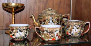 lot 2295 image: Antique Nippon Hand Painted Porcelain Tea set including Tea Pot, Creamer, and 2 Tea Cups with Very Fine Details and Lush Gilt