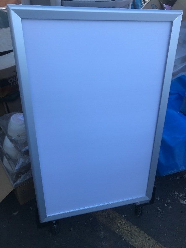 lot 1050 image: Large white board sign spring loaded in bottom just need to bolt into metal strips, Springs will let sign move in wind marker on both sides