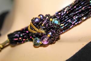 lot 2563 image: 2 Separate Strands of  Iridescent Deep Purple Necklaces and Coordinating Jeweled Bracelet and Clip jewelry