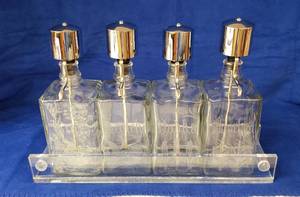 lot 6281 image: Set of 4 Etched Clear Glass Liquor Decanters in Holder  holder has Crack on one side