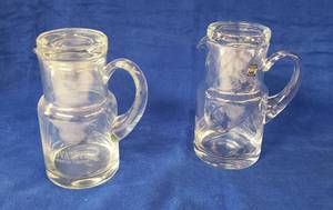 lot 6375 image: Pair of Crystal Tumble Ups  Pitcher & Glass Set  one is swirl pattern and one is plain wetching  8 in. tall x 6 in. wide (spout to handle)