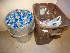 lot 1249 image: Large lot of aluminum cans- 2 trash cans full & can crusher attached to wall