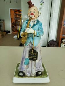 lot 6083 image: Melody in Motion Hand Painted Bisque Porcelain Clown with Saxophone. Needs AA Batteries