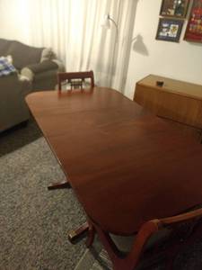 lot 8240 image: mahogany drop leaf table and 2 music back chairs 38 in Long 24 in wide with drop leaves down 65in with leaves up includes two extra leaves