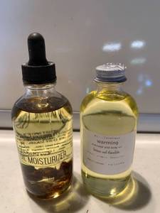 lot 6881 image: Two Bottles of Oil Moisturizer and Massage Body Oil Location Shelf E