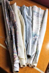 lot 6242 image: This Lot Contains (4) Fabrics Incl. (1) P. Kaufmann Paisley Chintz, (1) Small Lt. Blue Silk Sheen, (1) Heavy Roll of Off White Textured Solid, and (1) SW Print in Pastels