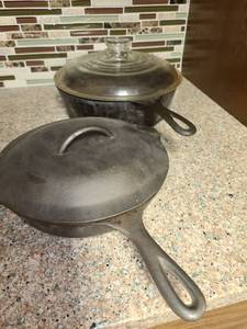 lot 1036 image: Cast Iron Skillets. Large is a Wagner #8 with a lid...lid has small chip....smaller is a #6 with lid.