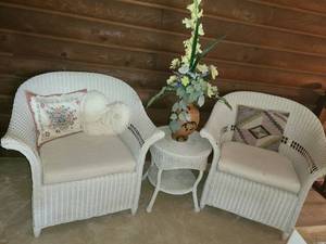 lot 1103 image: 2 Wicker Chairs and a Wicker Table with Faux Flowers. Chairs are 34 tall x 37 wide. The table is 22 tall x 18 diameter