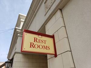 lot 6162 image: Metal restroom sign on building