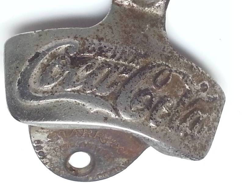 lot 1230 image: Slightly rusty forged steel Coca Cola bottle cap opener off a case somewhere