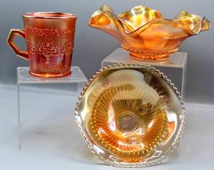 lot 1472 image: (3) Vintage Carnival Glass Pumpkin and Marigold Iridescent Ribbon Footed Bowl, Ruffle Bowl and Fenton Marigold Orange Tree Mug