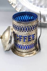 lot 1527 image: Pierced Silverplate Coffee Canister w Cobalt Blue Glass Liner, 16 Cromwell Hand Wrought Hammered Aluminum Serving Tray, Brooklyn Silver Co. Silent Butler Dust Pan and set of salt & pepper shakers